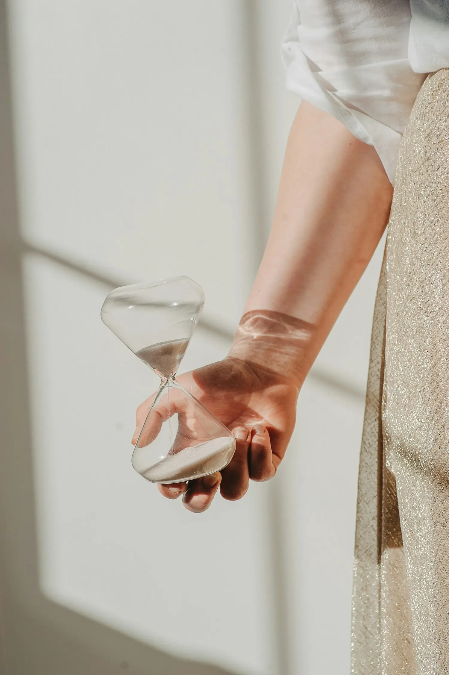 Frau, die Sanduhr in einer Hand hält